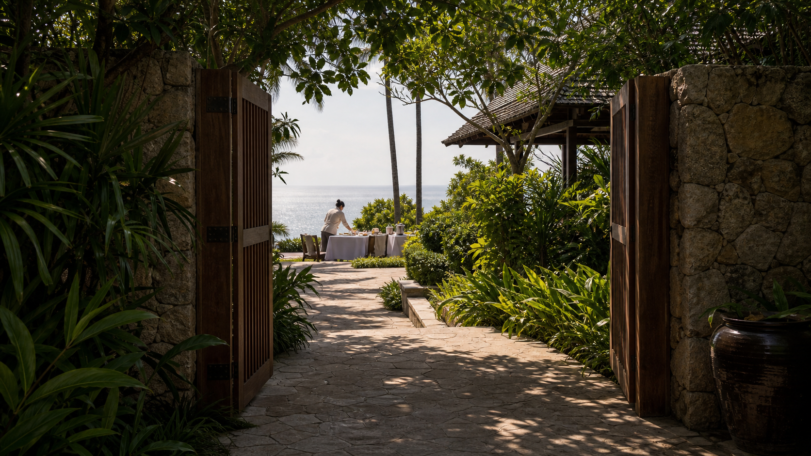 Amanpuri and the Phuket headland estates — secluded gate arrival in local stone.